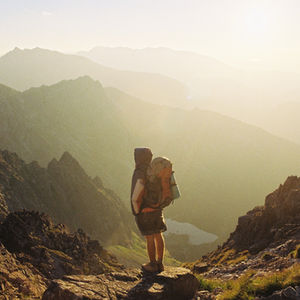 Hiker standing on a mountain peak overlooking a valley