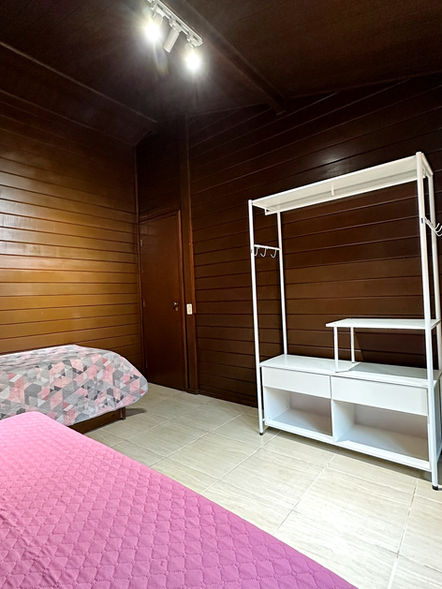 Vista da acomodação do Quarto de Solteiro com 2 bicamas e armário conceito aberto.