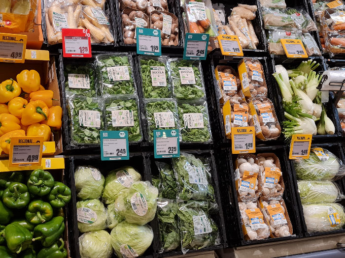 Obst und Gemüsetheke eines deutschen Lebensmittelladens. Viele Lebensmittel sind in Plastik verpackt. 