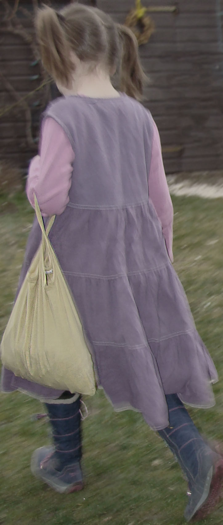 Mädchen mit einer gelben Einkaufstasche von hinten