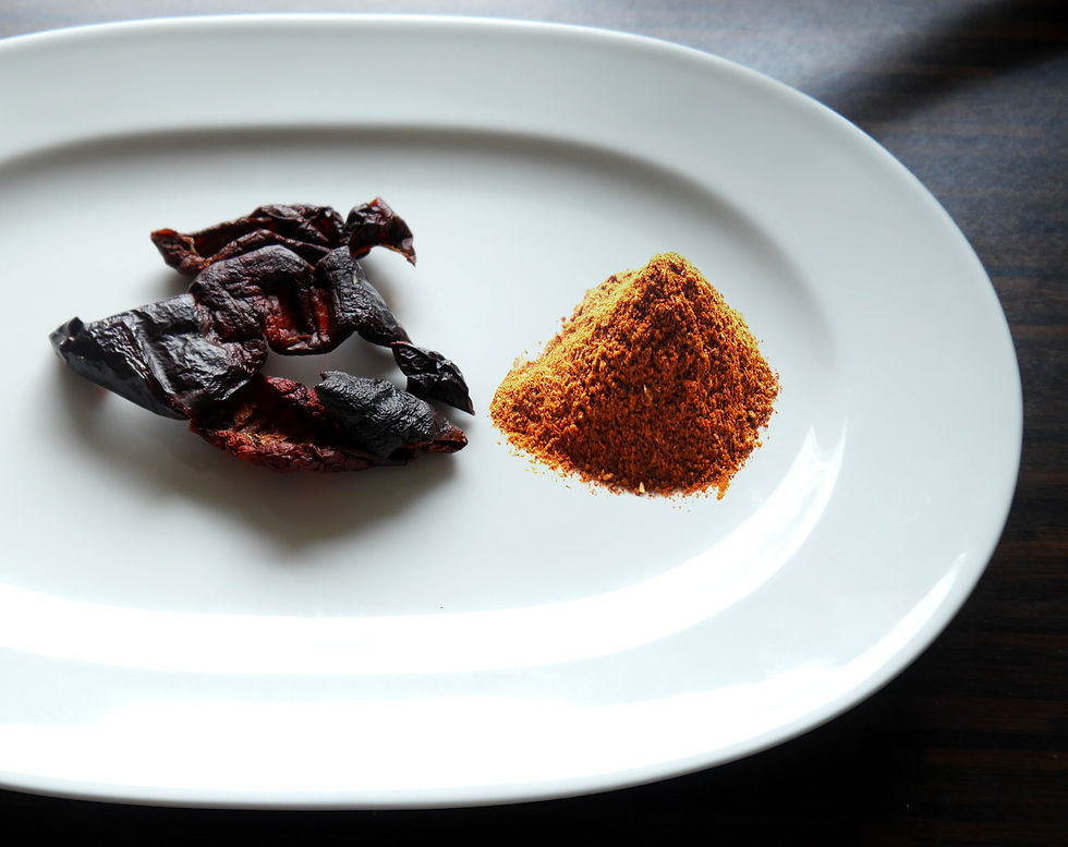 ein weißer Teller mit getrockneten Tomaten und einem Haufen Paprikapulver