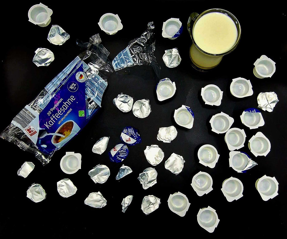 Kaffeesahne -Verhältnis Produkt Verpackung zu Produkt. Ein kleines Glas Sahne umringt von vielen Einwegbehälter aus Kunststoff, Aludeckeln und Plastikfolie.