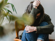 Mujer joven sentada estresada — síntomas sin causa médica