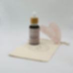 Radiance Facial Oil and rose quartz Gua Sha on a cream canvas pouch. Wildberry Skincare