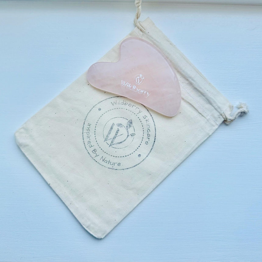 Pink Natural Jade Gua Sha Tool, Anti-Aging Facial Sculpting on a pouch Wildberry Skincare.