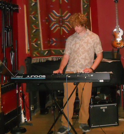 HYPNOTIC playing the keyboard on stage.