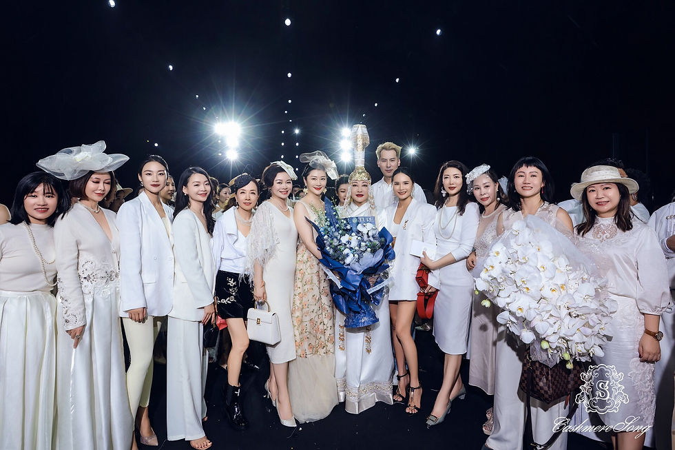 Designer Song Hong posing with fans after the event, dressed in elegant white attire.