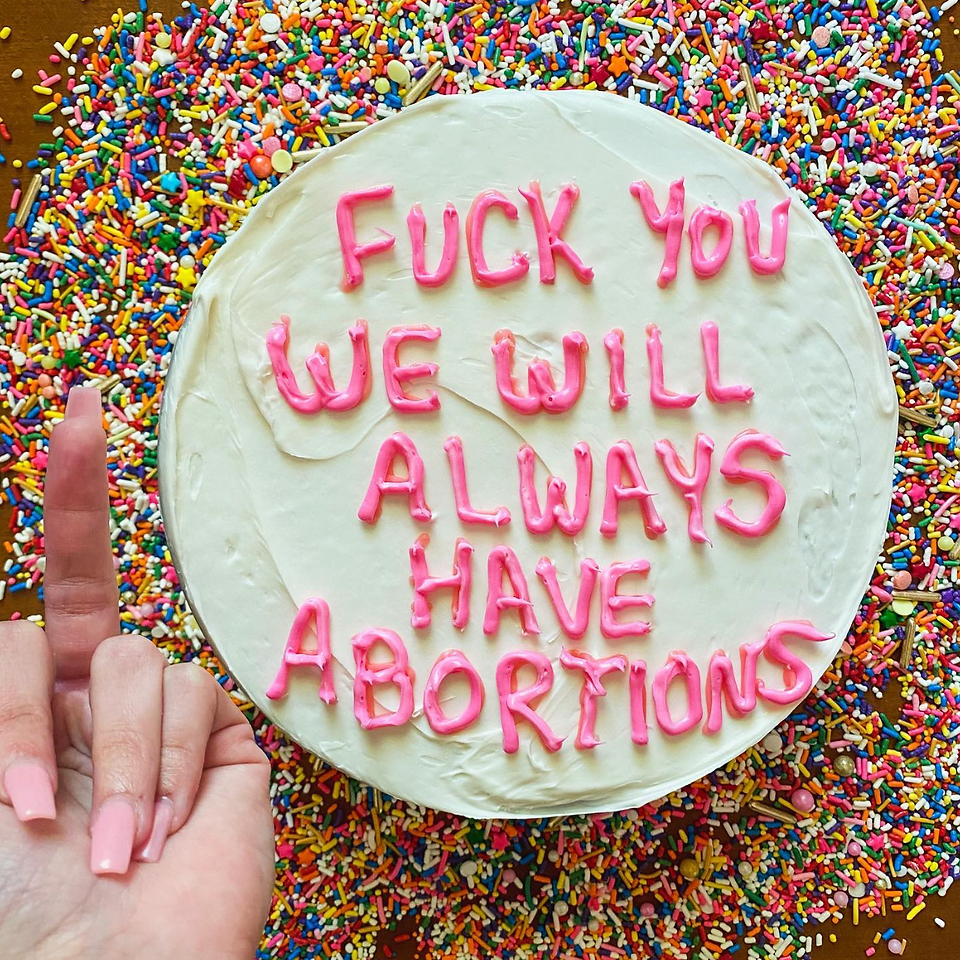 green and pink frosted cake with the message "fuck you we will always have abortions"