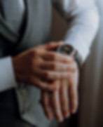 closeup-cropped-frame-man-puts-watch-with-leather-belt-is-dressed-stylish-suit-white-shirt