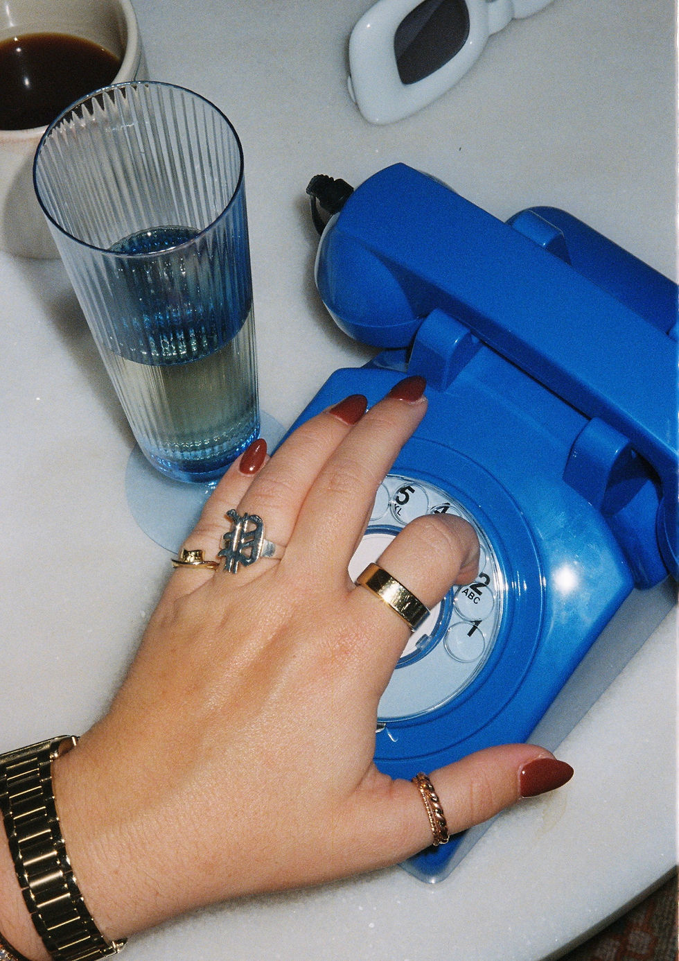 hand on blue rotary phone dialing