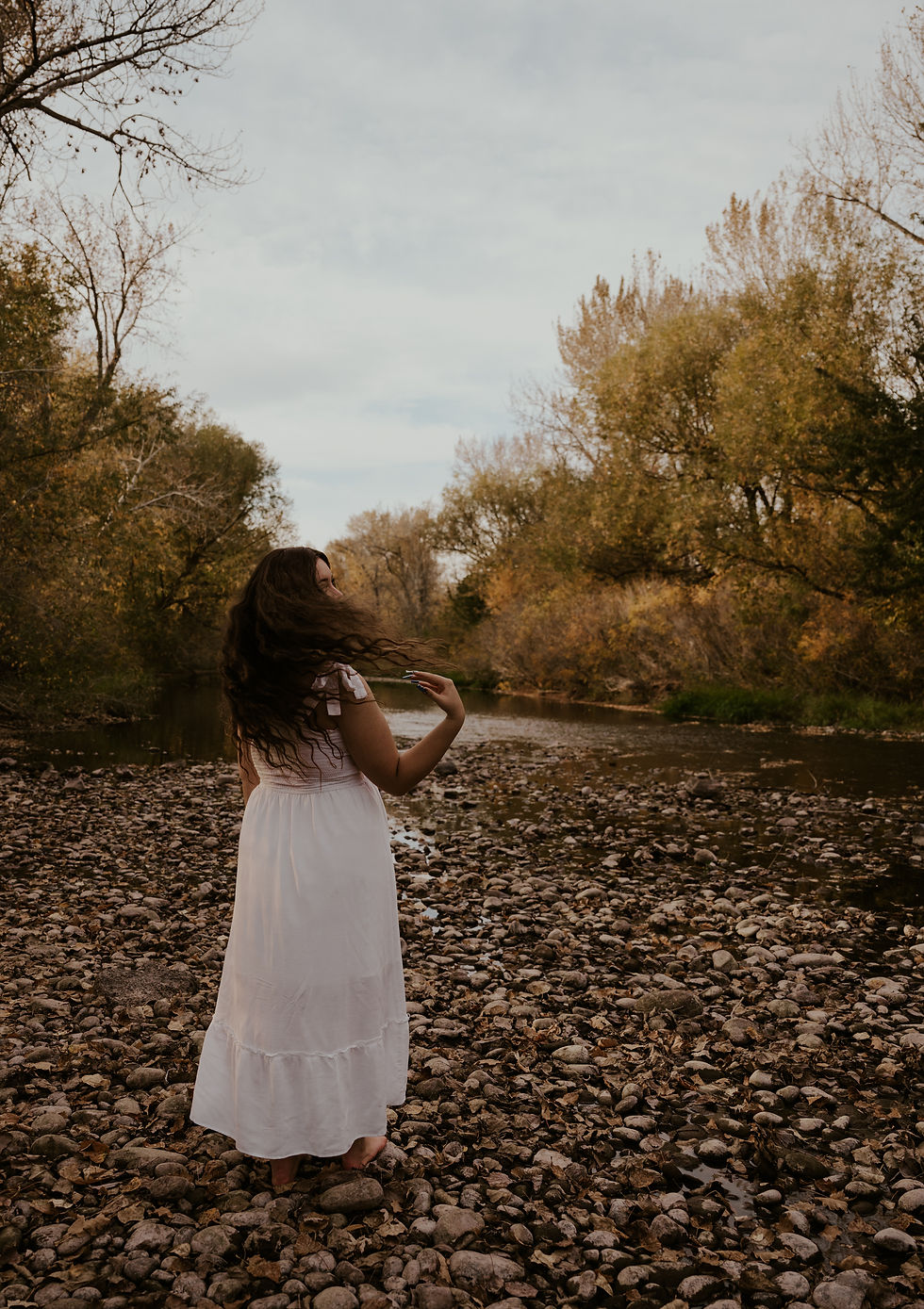 young woman in white dress in river
