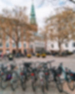 Parked bicycles line the edge of cobblestone streets in Copenhagen. 