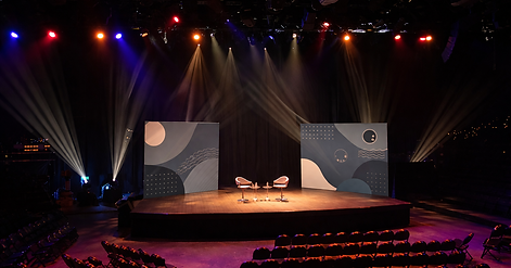 Modern lecture stage with dramatic lighting.png