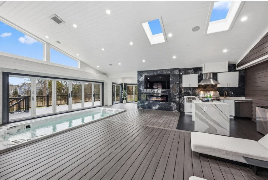 Indoor wellness spa pavilion with hydropool swim spa, skylights, and indoor-outdoor design in luxury estate in Hartland Aldie VA