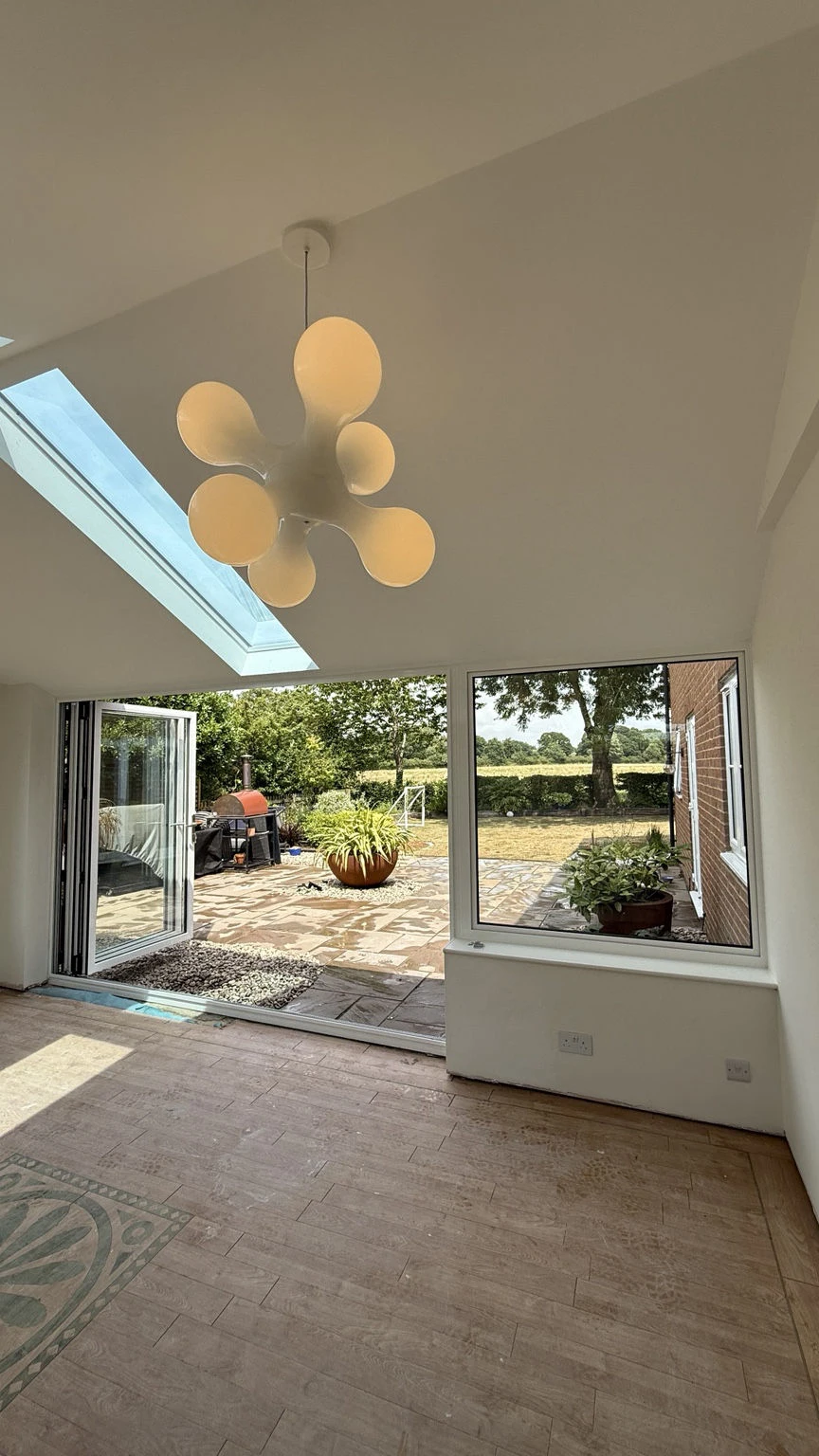 Inside the same Concept Glazing installation, showing its plastered ceiling, roof glazing and garden opening