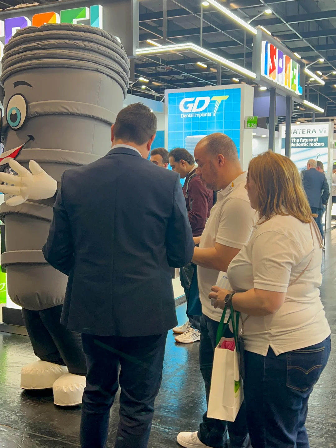 Dentists interested in the GDT products, talking to martin and smilix in the GDT Booth background - IDS 2025