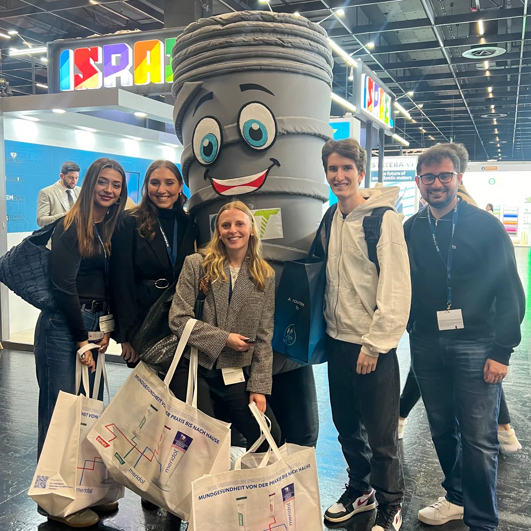 3 women and 2 men posing with smilix infront of the GDT booth - IDS Cologne 2025