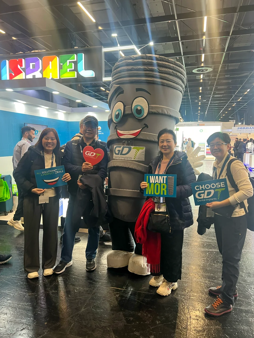 2 women and 2 men posing with smilix infront of the GDT booth - IDS Cologne 2025
