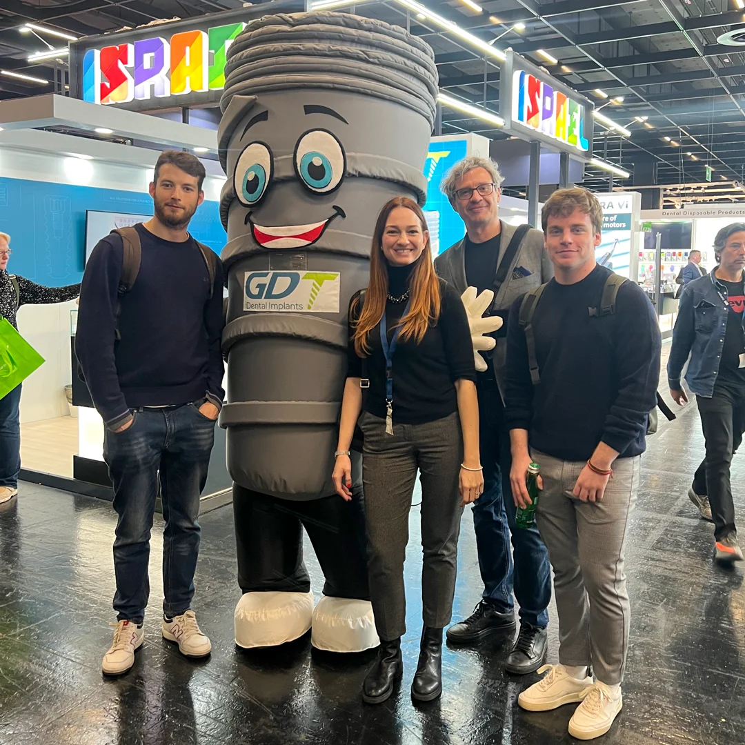 3 men and a women posing with smilix infront of the GDT booth - IDS Cologne 2025