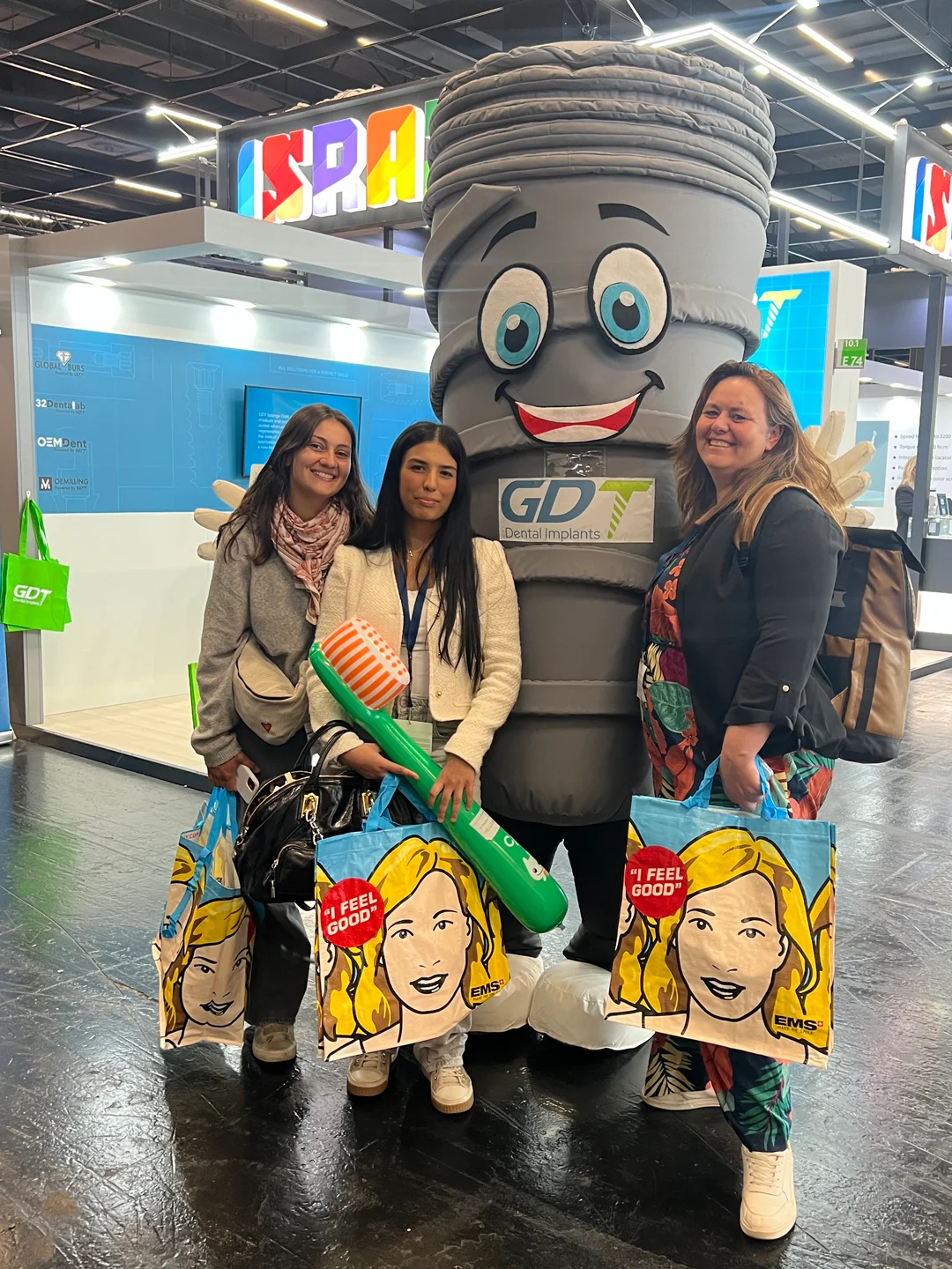 3 women and a guy posing with smilix infront of the GDT booth - IDS Cologne 2025