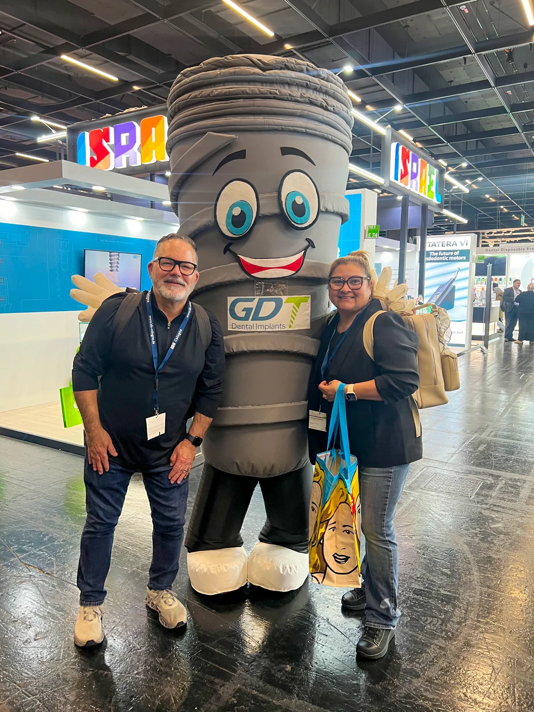 Dentist couple posing with smiling infront of the GDT Booth - IDS Cologne 2025