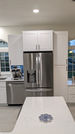 Kitchen island and stainless refrigerator in remodeled Pinellas County kitchen