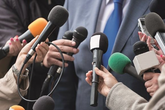 media crowding around holding microphones