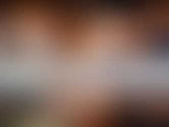 A cautious-looking Asian man using a laptop to deposit money into an online casino account, holding a bank card while reviewing payment details in a casino-style setting.