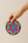 Hand holding teal, pink, and brown woven coin purse