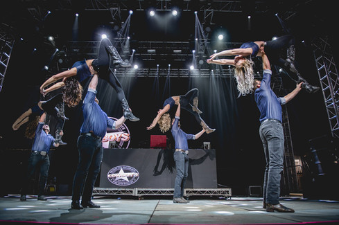 Country swing dancers performing live on the Cowboys Music Festival main stage in Calgary, demonstrating modern country swing technique in a large-scale outdoor concert environment.