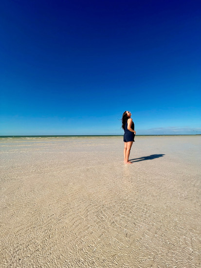 girl standing along the long sand strip of Punta Mosquito in Holbox, Mexico