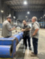 Three men inspecting large blue C&L cylinder
