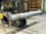 Large hydraulic cylinder barrel on a forklift in a repair facility, awaiting inspection and rebuild.