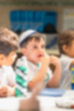 Sinai Learning Lab student wearing a kippah listening thoughtfully during a classroom discussion.