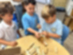 Sinai Learning Lab students building with wooden blocks together during a hands-on classroom activity.