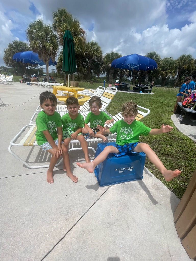 Camp Sinai children sitting together outdoors enjoying lunch time during summer camp.