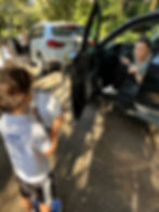 Sinai Learning Lab students selling hot cocoa kits to a parent during a school fundraiser at carpool.