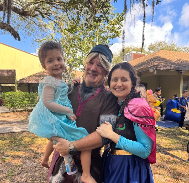 Family smiling together outdoors during a Temple Sinai community event.