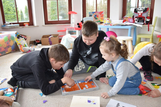 Three children playing with a toy in a children room.