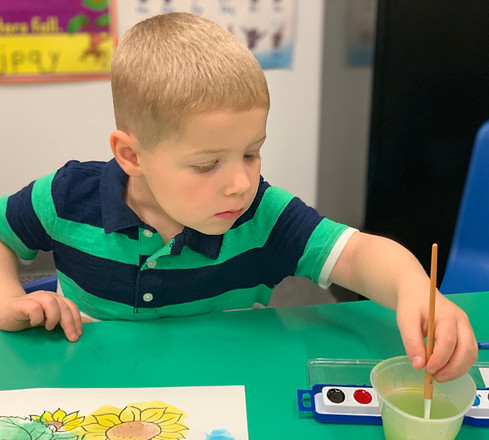 young boy painting at So Big Child Development Center