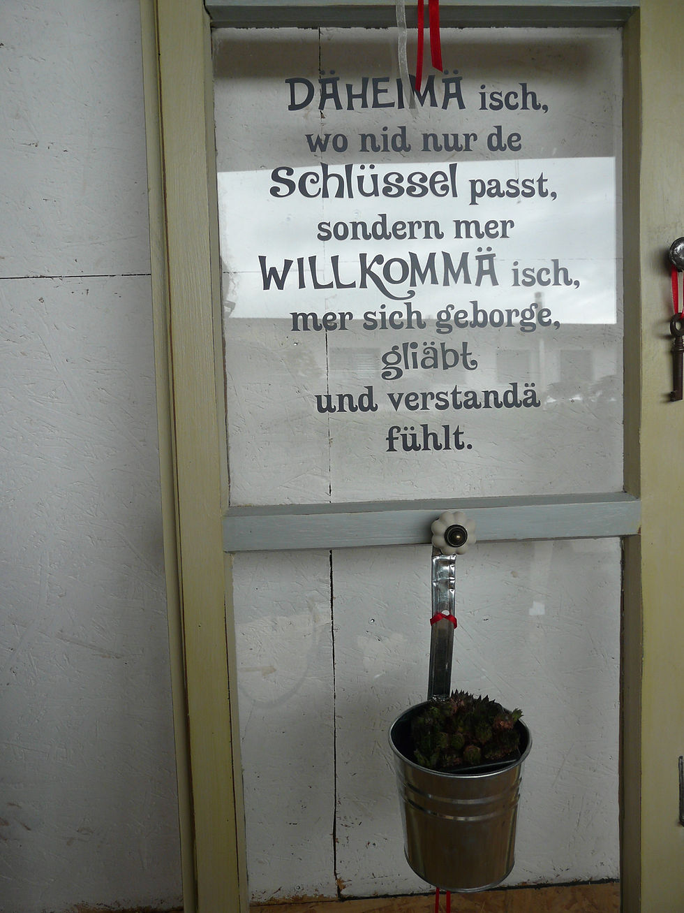 Miniaturbild: Altes Fenster mit Spruch und Pflanzenhalter