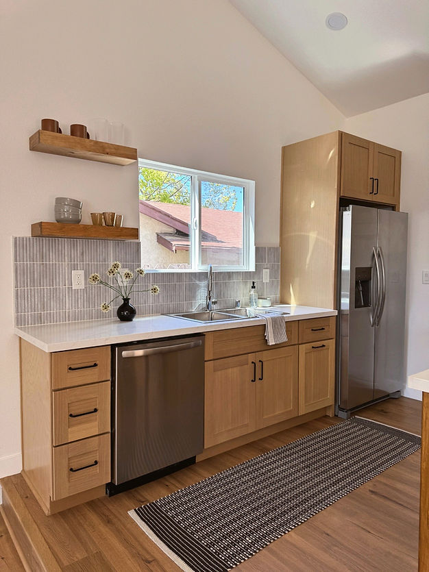 Kitchen renovation featuring custom wood cabinetry and stainless steel appliances