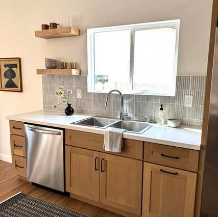 Scandinavian-style kitchen with natural wood cabinets and tile backsplash