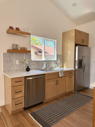 Light wood kitchen cabinets with tile backsplash and open shelving