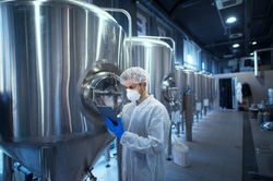 factory-worker-technologist-protective-uniform-with-hairnet-mask-controlling-food-producti