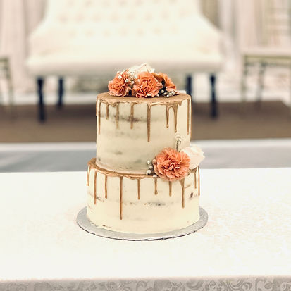 naked wedd cake with rose gold drips and fresh floralsng
