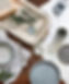 Paint pots with various grey colours resting on a tray and fabric swatches