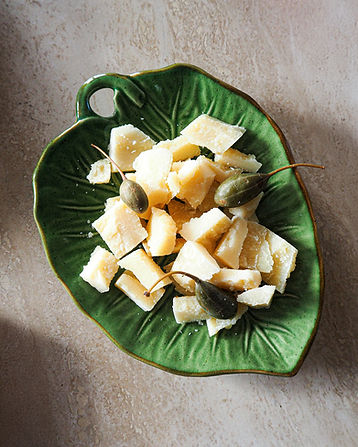 Zoom sur une assiette de Parmigiano Reggiano avec des câpres-tiges