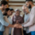 a small group in prayer, hands joined, evoking a sense of heartfelt worship and unity