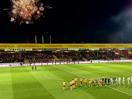 Night photo of the John Hunter stand as the teams walk out onto the pitch. Fireworks and a banner that reads 'Everyone to Hampden' are visible.
